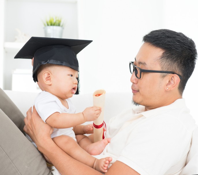 Asian family lifestyle at home. Baby with graduation cap holding certificate. Child and father early education concept.