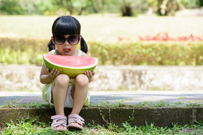 Little child with sunglasses and big slice of watermelon sitting in the park ** Note: Soft Focus at 100%, best at smaller sizes